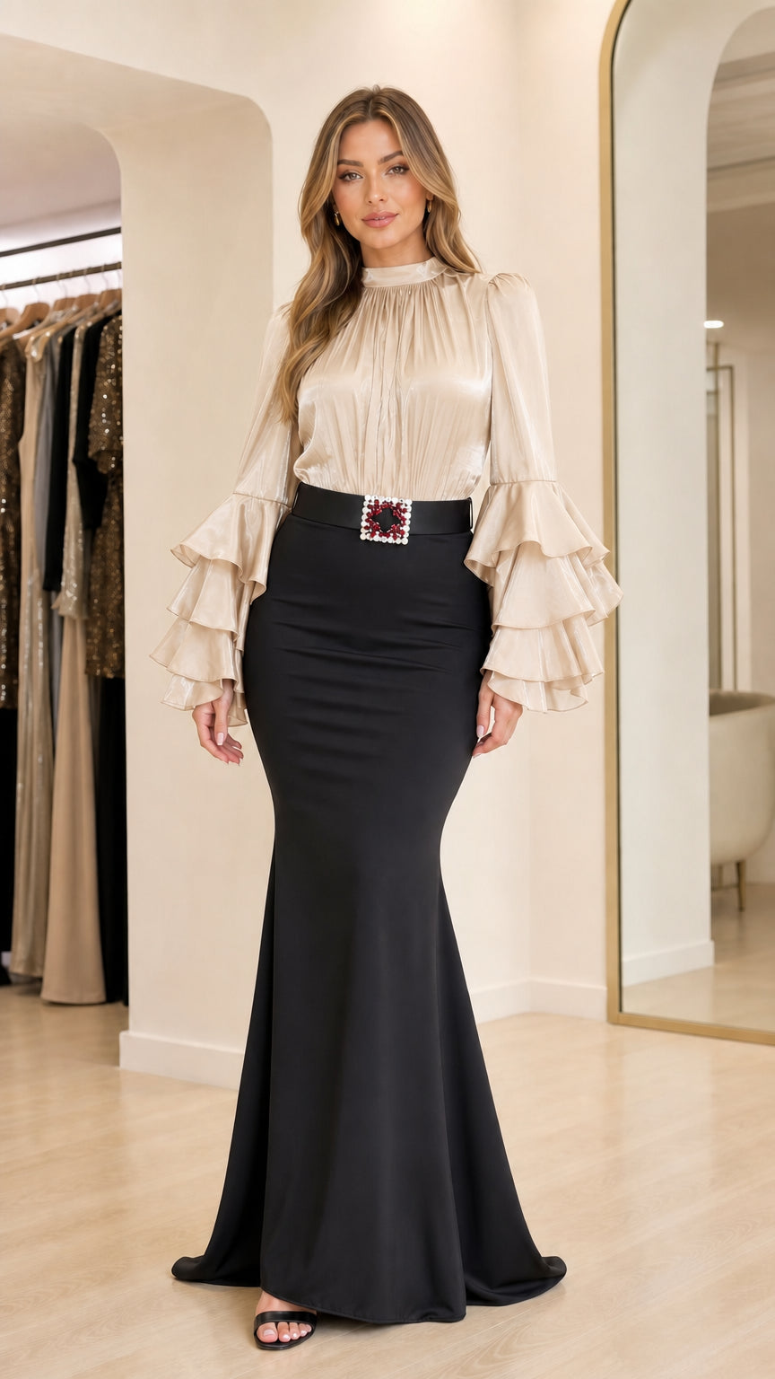 Model wearing champagne ruffle sleeve blouse and black mermaid skirt