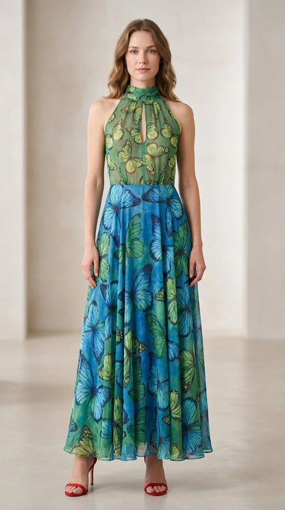 Front view of woman wearing emerald blue butterfly print halter maxi dress