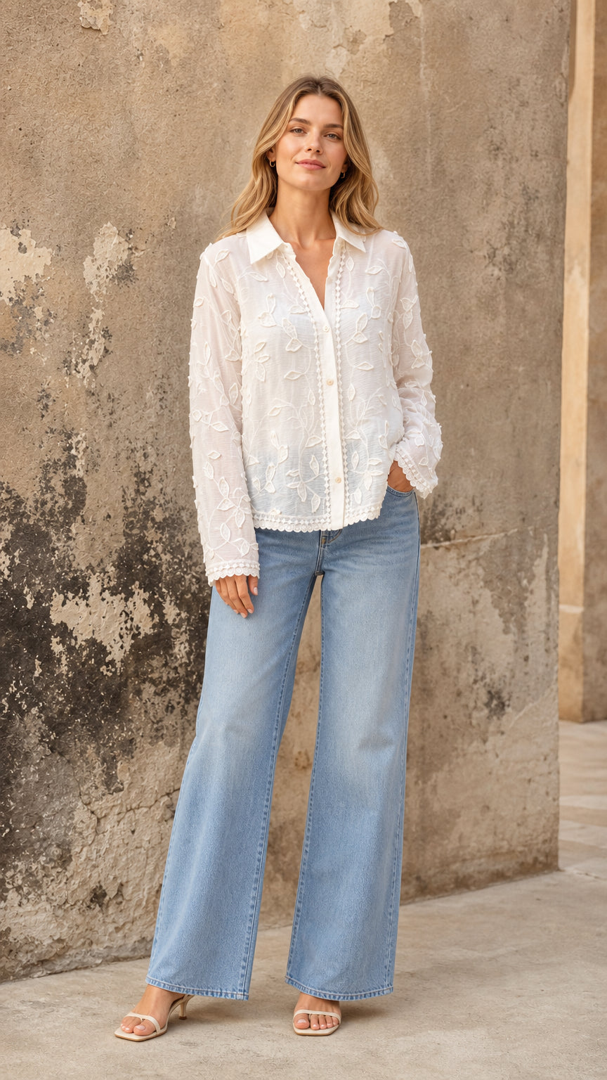 White embroidered floral button-up blouse styled with light-wash wide-leg jeans