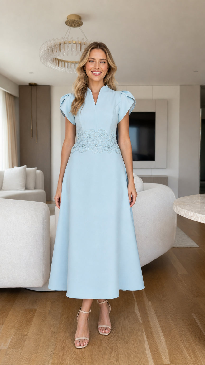 Front view of model wearing light blue A-line midi dress with beaded floral waist