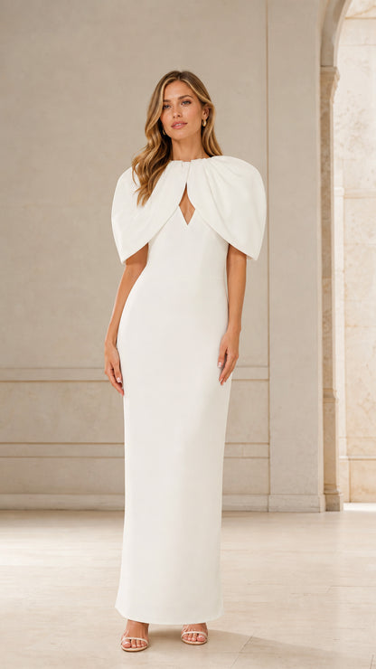 Front view of woman wearing white cape maxi dress
