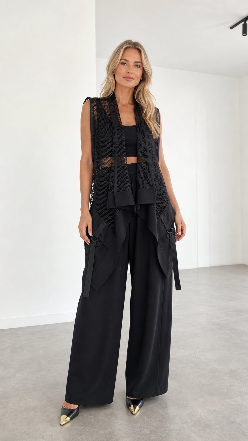 Model wearing black mesh paneled vest and wide-leg pants set front view