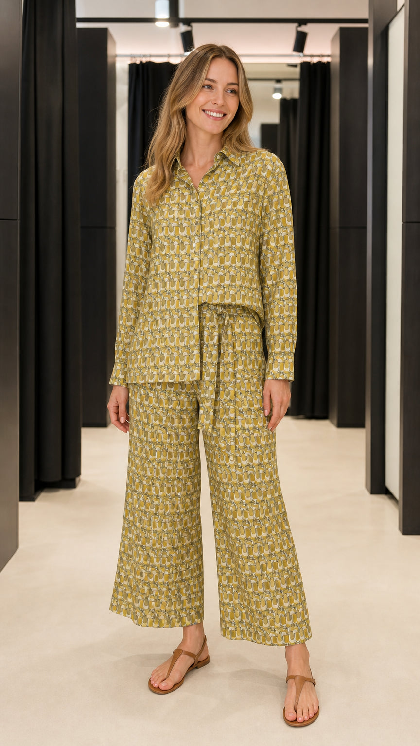 Front view of woman wearing olive geometric print button-down shirt and matching wide-leg pants set