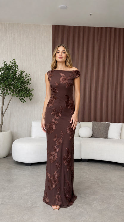 Model wearing brown floral applique off-the-shoulder evening dress front view