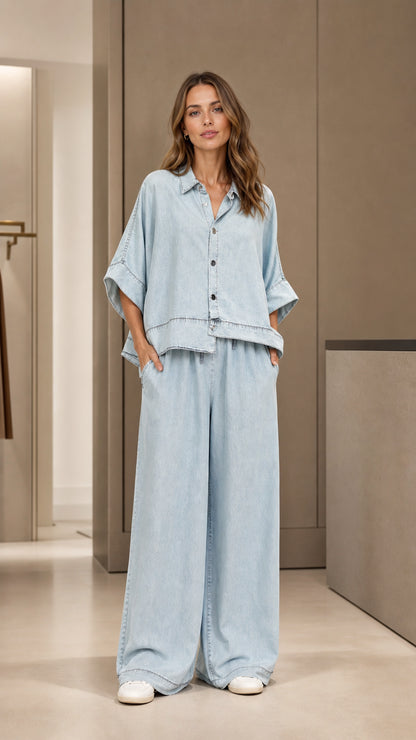 Full front view of model wearing light blue denim two-piece set with sneakers