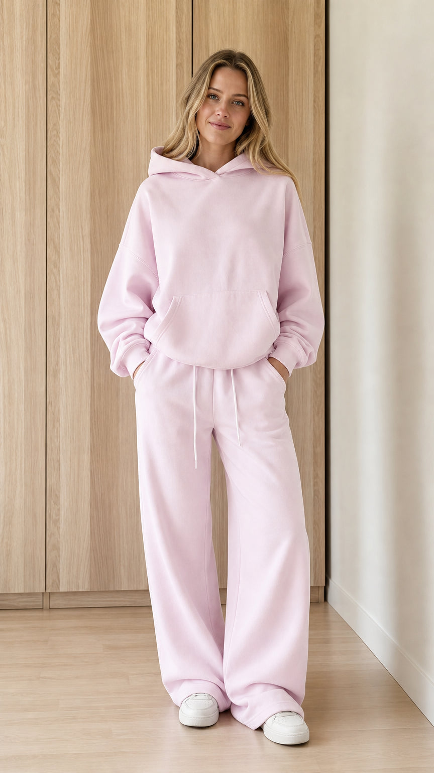 Model wearing a blush pink women's hoodie and wide-leg sweatpants set from the front