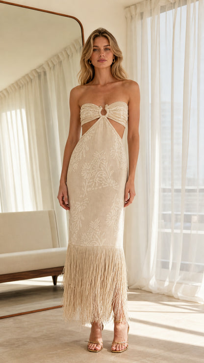 Front view of model wearing beige strapless cutout midi dress with fringe hem