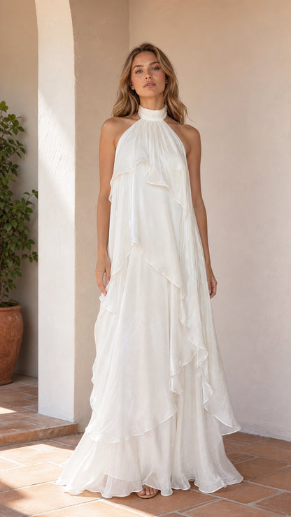Front view of model wearing white flowing ruffle halter maxi dress
