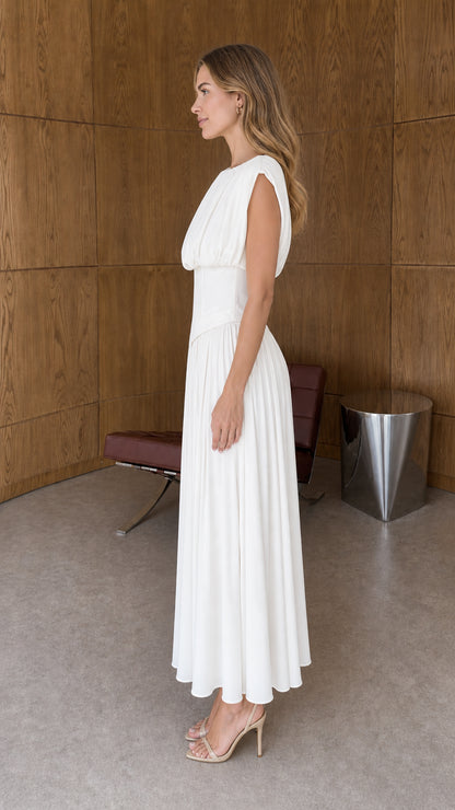 Side profile view of woman wearing white sleeveless pleated midi dress