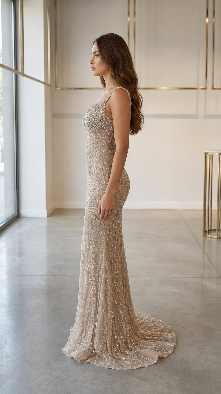 Side profile view of champagne evening gown with sweep train