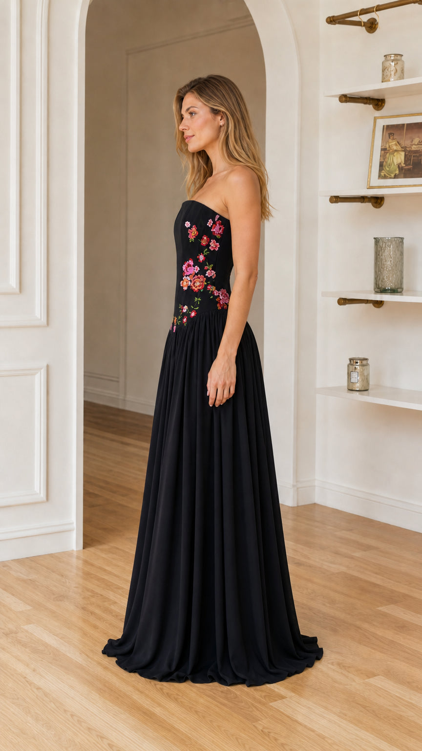 Side profile view of woman in black embroidered maxi dress