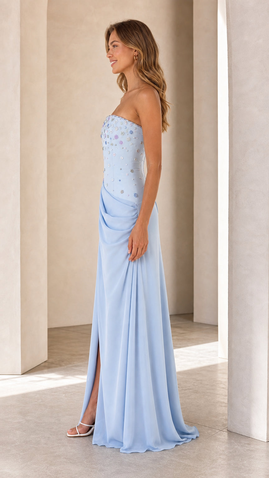 Side profile of model in Light Blue strapless formal maxi dress with high side slit