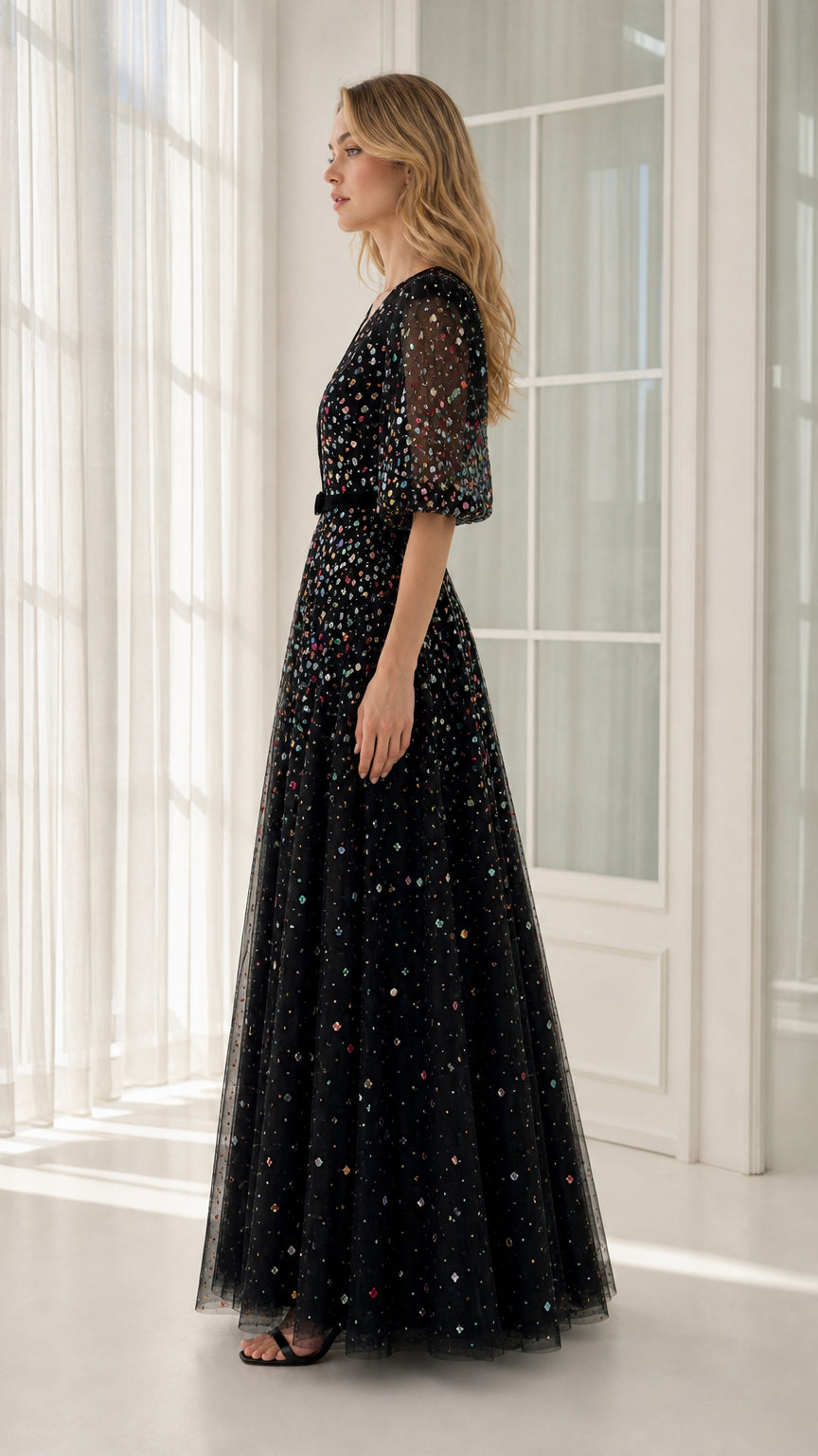 Side profile view of black embellished evening gown