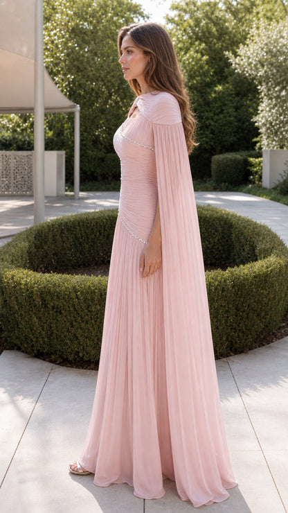 Side profile of woman wearing blush pink floor-length cape formal dress