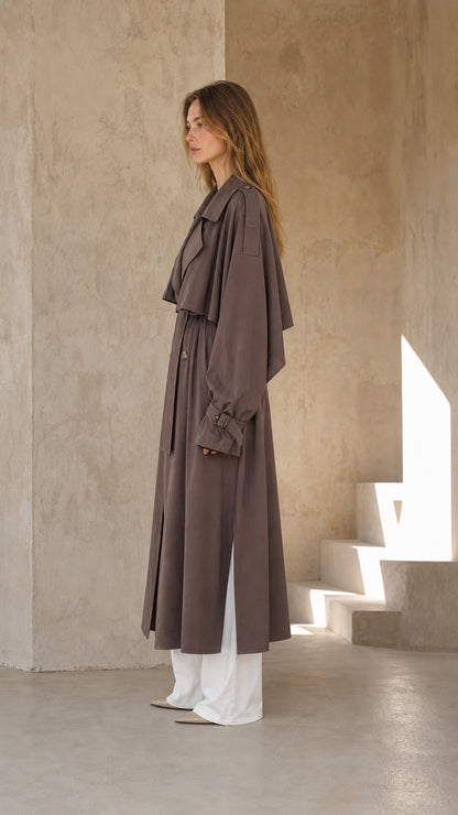 Side profile of woman wearing dark taupe long trench coat