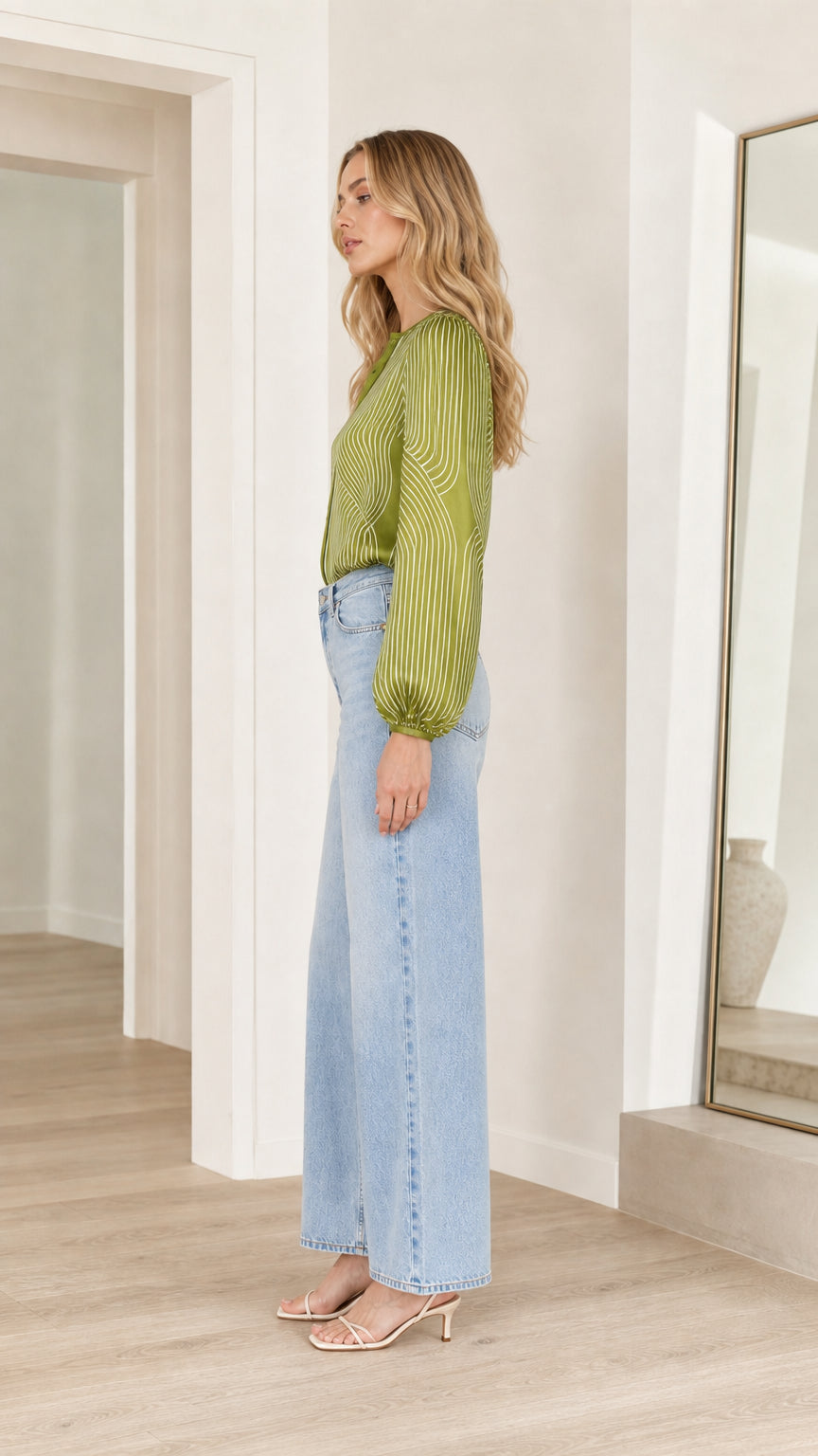 Model wearing olive striped satin blouse, side profile