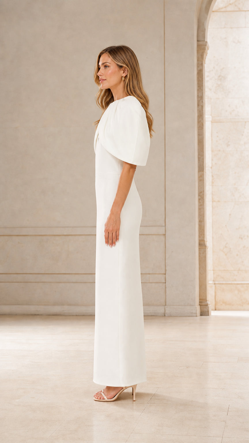 Side profile of woman in white formal cape dress