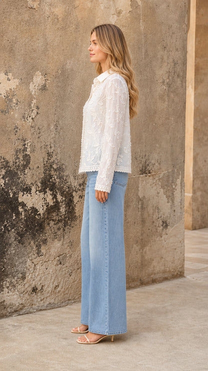 Side view of white floral embroidered blouse with long sleeves and pointed collar