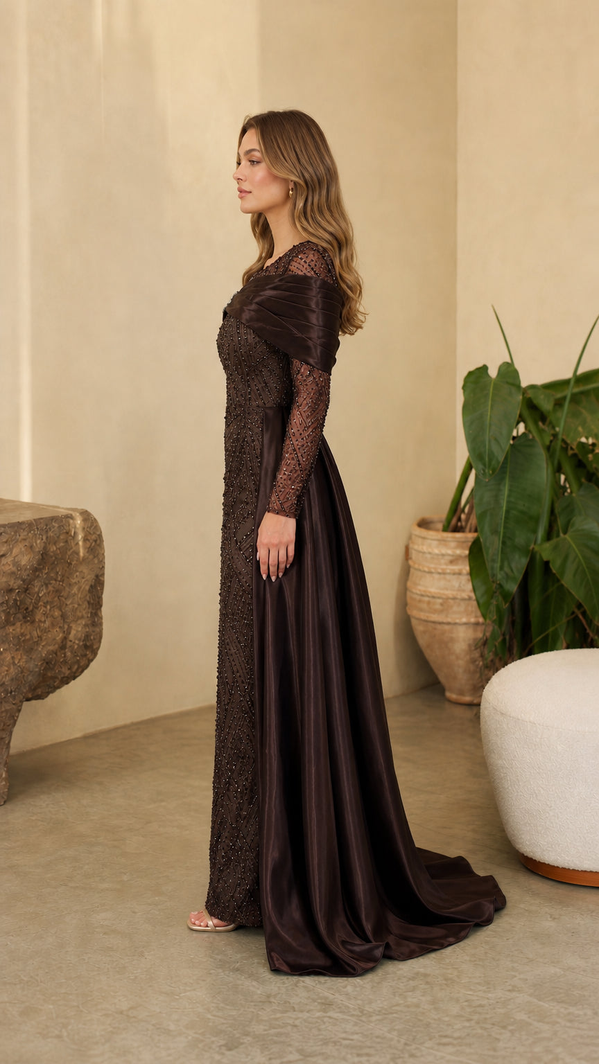 Side angle view of model showing the profile and flowing satin train of the Chocolate Brown gown
