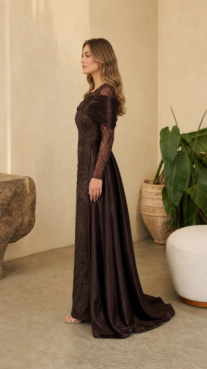 Side angle view of model showing the profile and flowing satin train of the Chocolate Brown gown