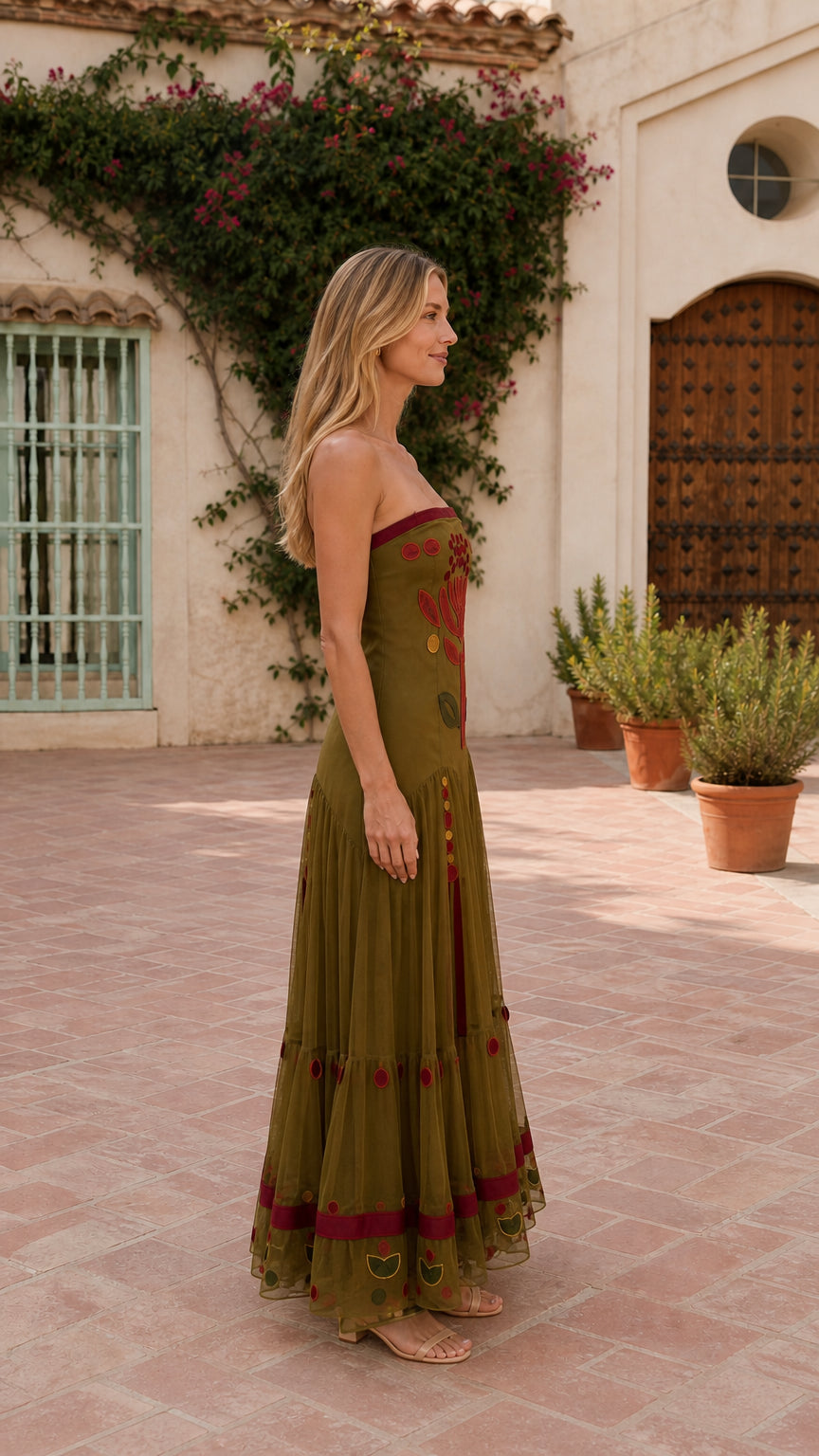 Side profile of woman in olive embroidered maxi dress