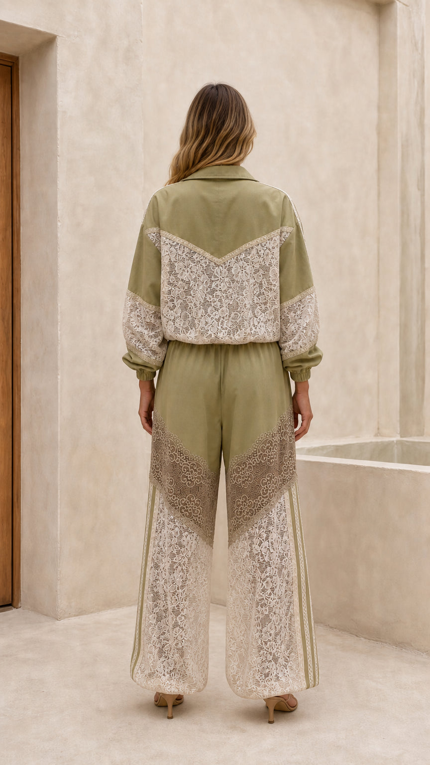 Back view of woman in sage green lace track jacket and trousers