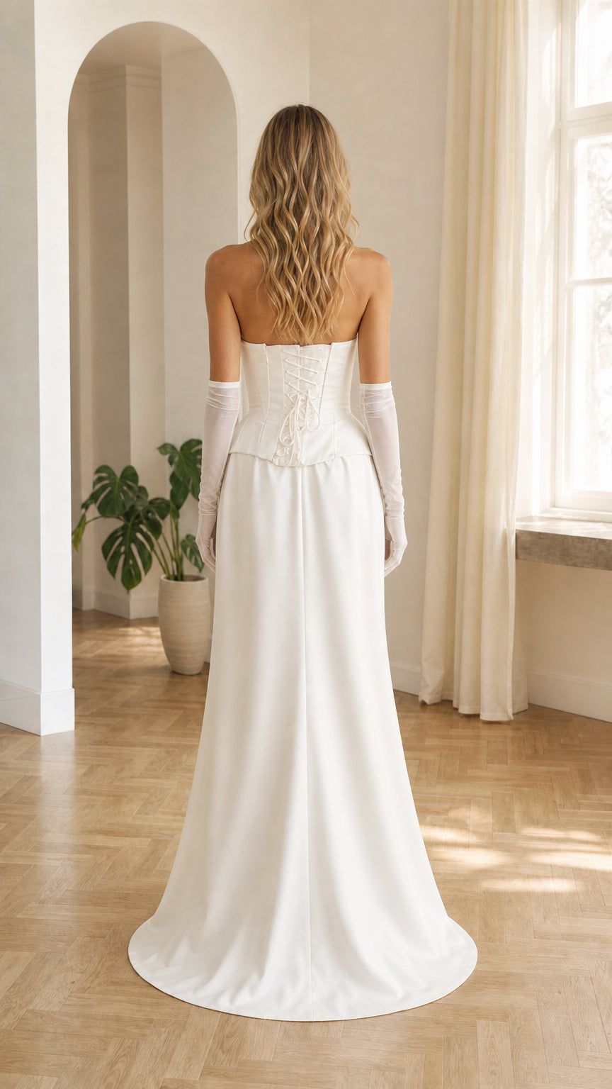 Back view of white strapless corset maxi dress showing lace-up detail