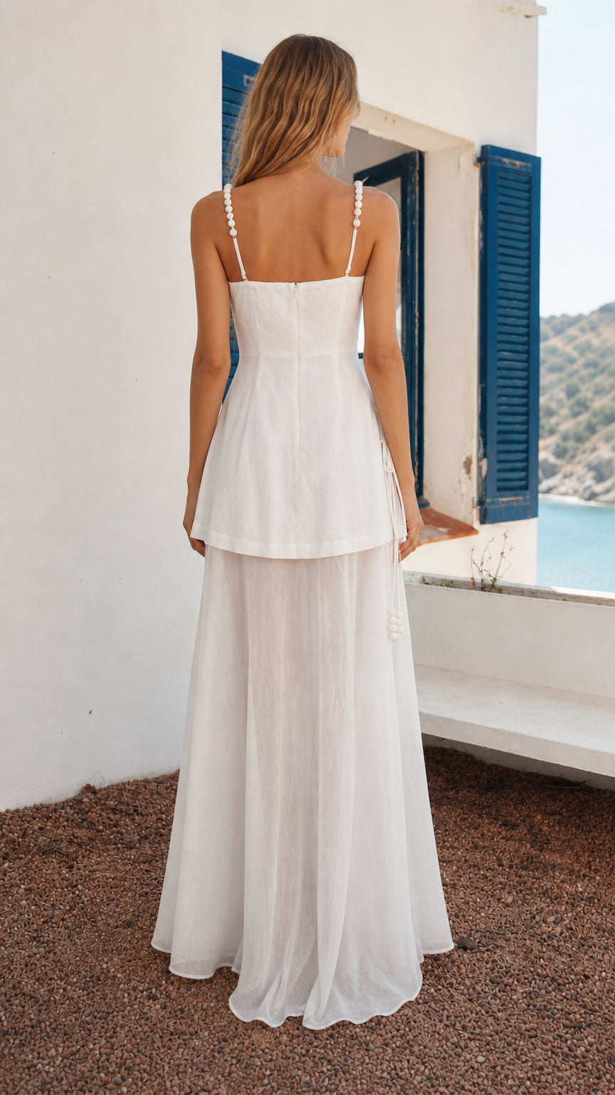 Back view of woman in white layered maxi dress