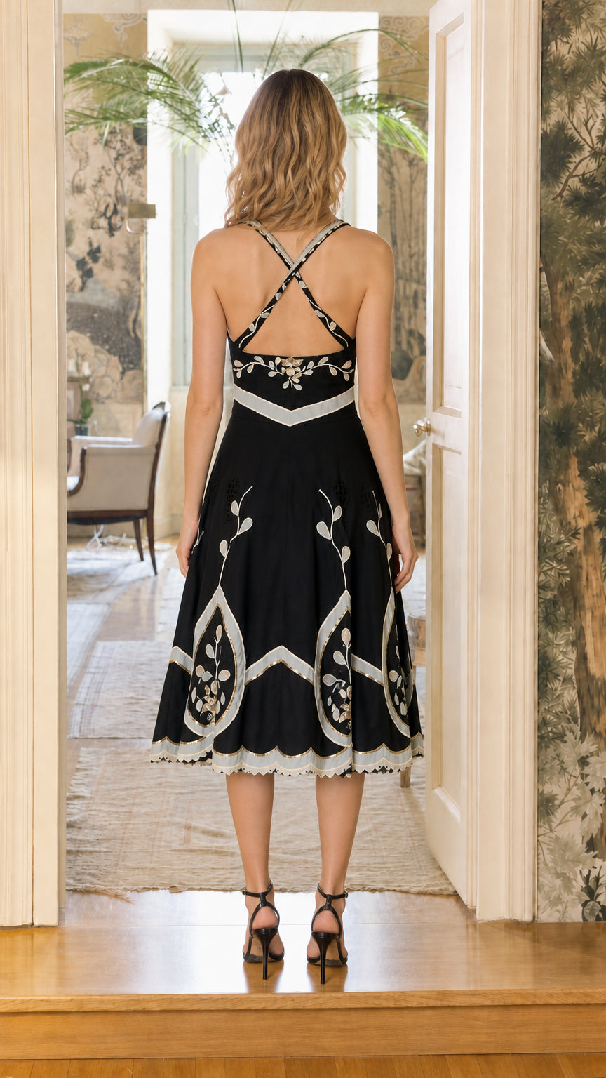 Back view showing cross-back straps on black midi dress