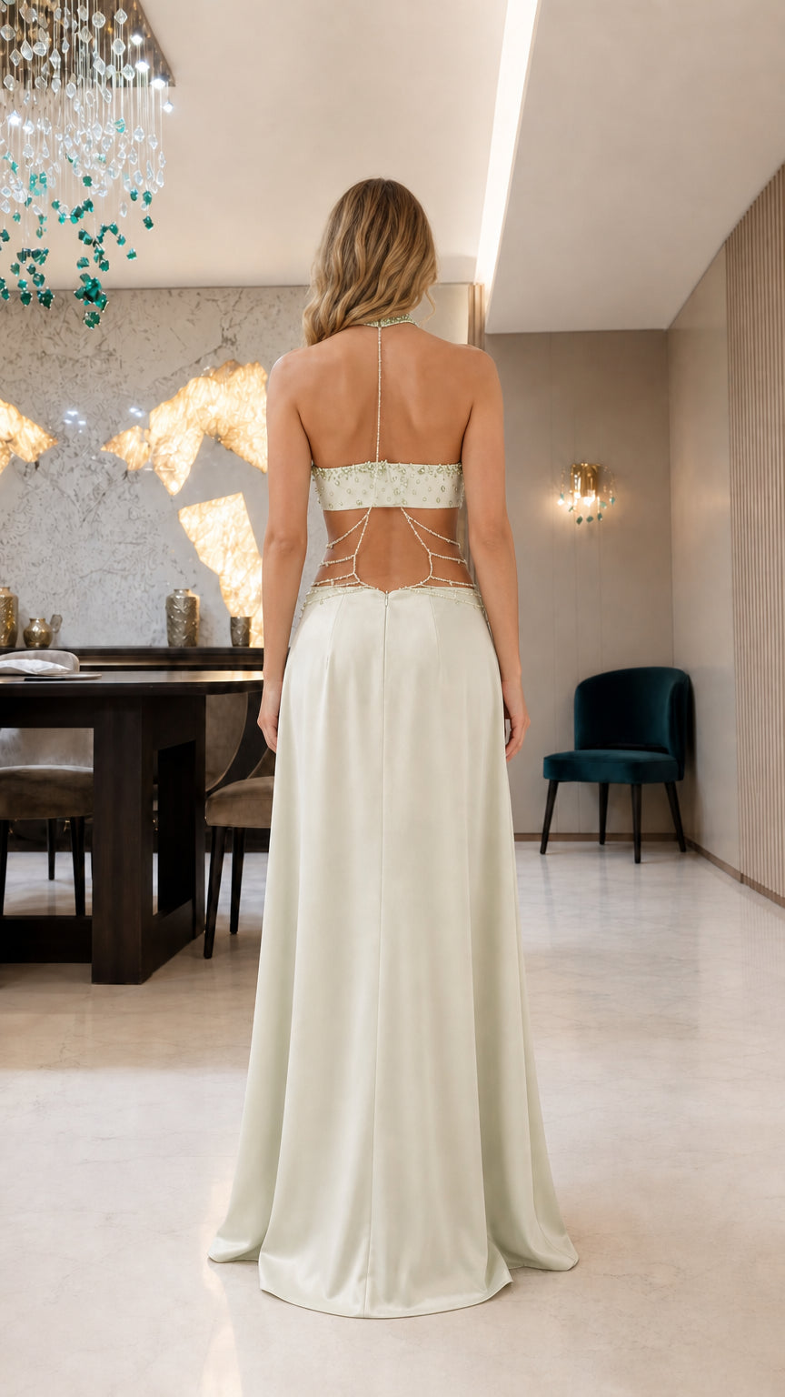 Back view of model showing open back and beaded detailing on sage green dress