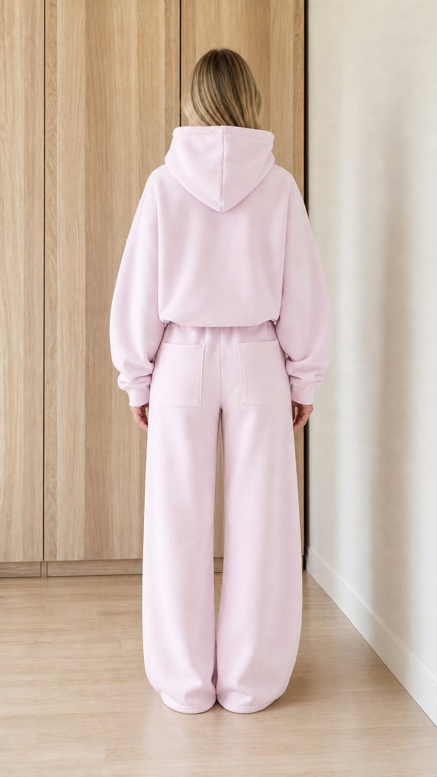 Back view showing the hood and full-length wide-leg pants in blush pink
