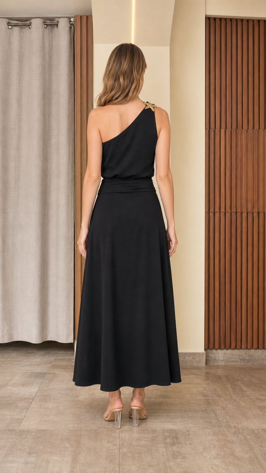Back view of woman wearing black one-shoulder top and flowing maxi skirt