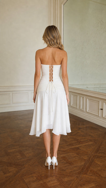 Back view of model in white strapless midi dress with lace-up detail