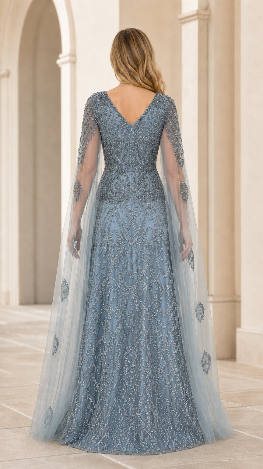 Back view of dusty blue cape gown with elegant V-back design