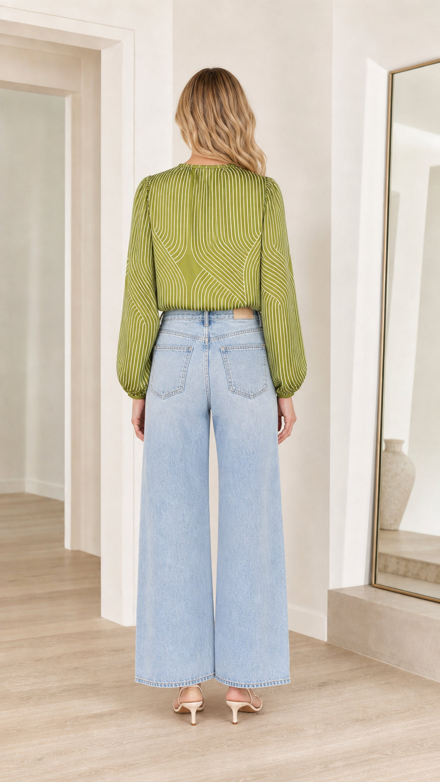 Model wearing olive striped satin blouse, back view