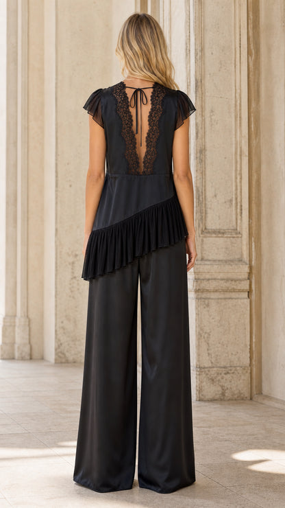 Back view of model showing lace back detail and tie closure on black satin set
