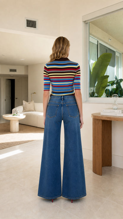 Back view of model wearing striped knit polo shirt and wide leg denim