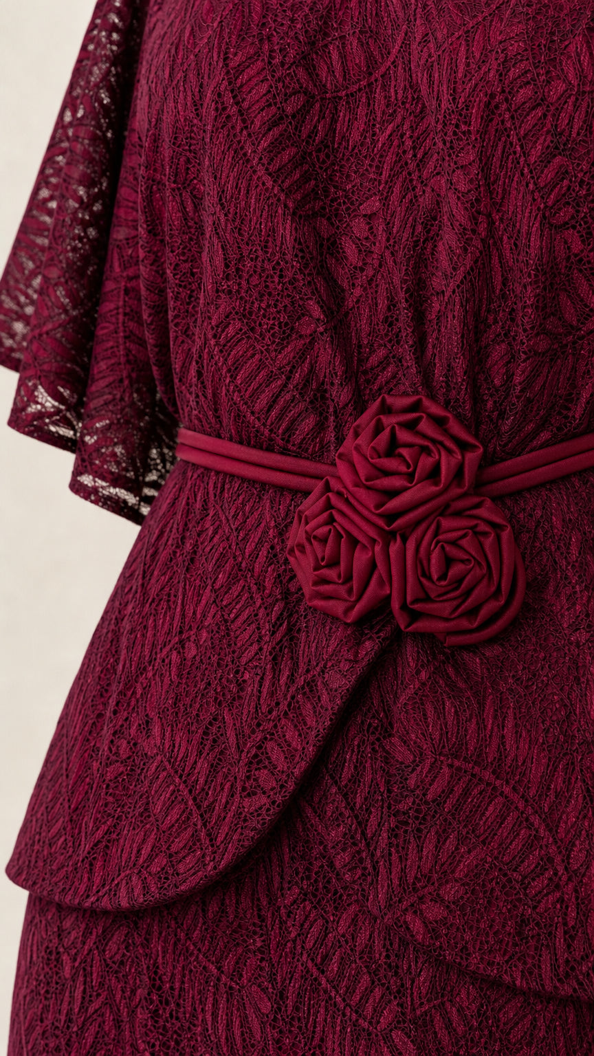 Close-up detail of floral waist rosettes and lace fabric
