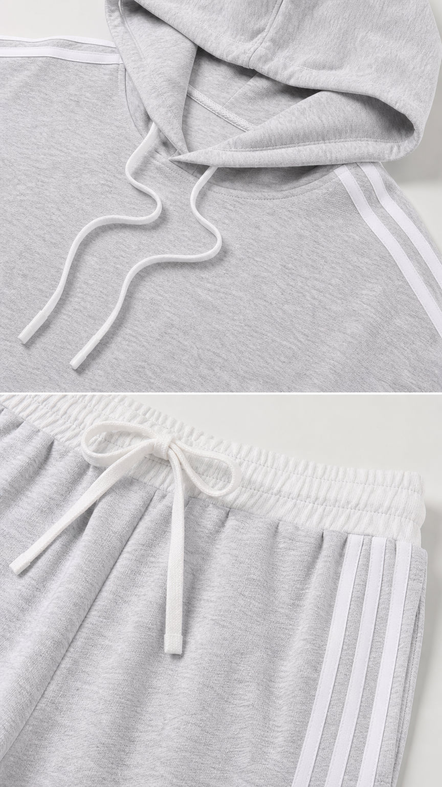 Close-up of the light gray drawstring hoodie and striped elastic-waist pants details