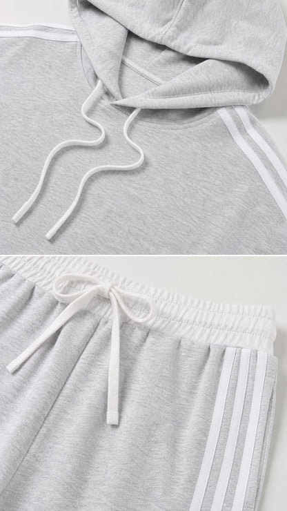 Close-up of the light gray drawstring hoodie and striped elastic-waist pants details