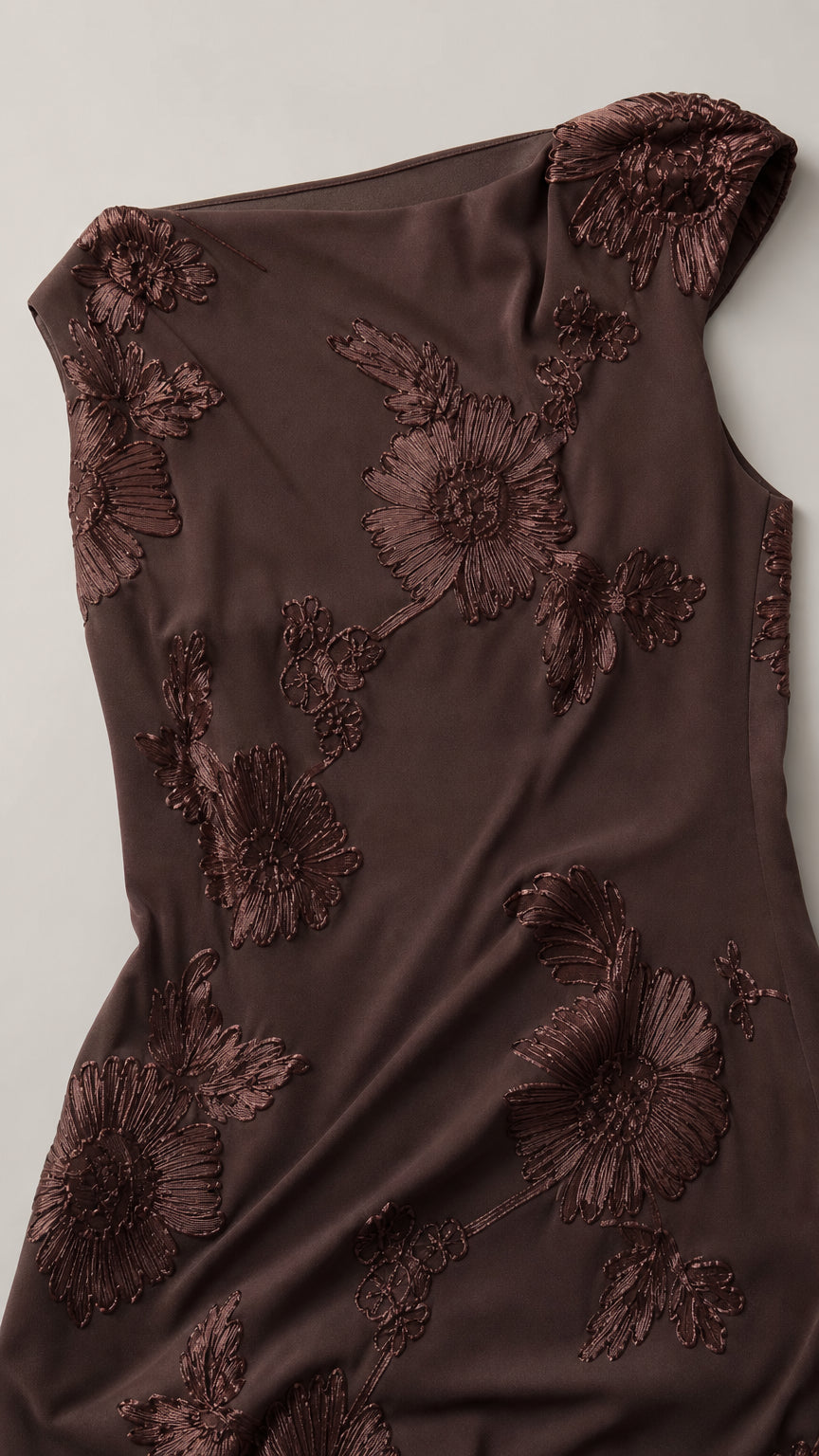 Close-up of brown dress fabric and floral embroidery detail