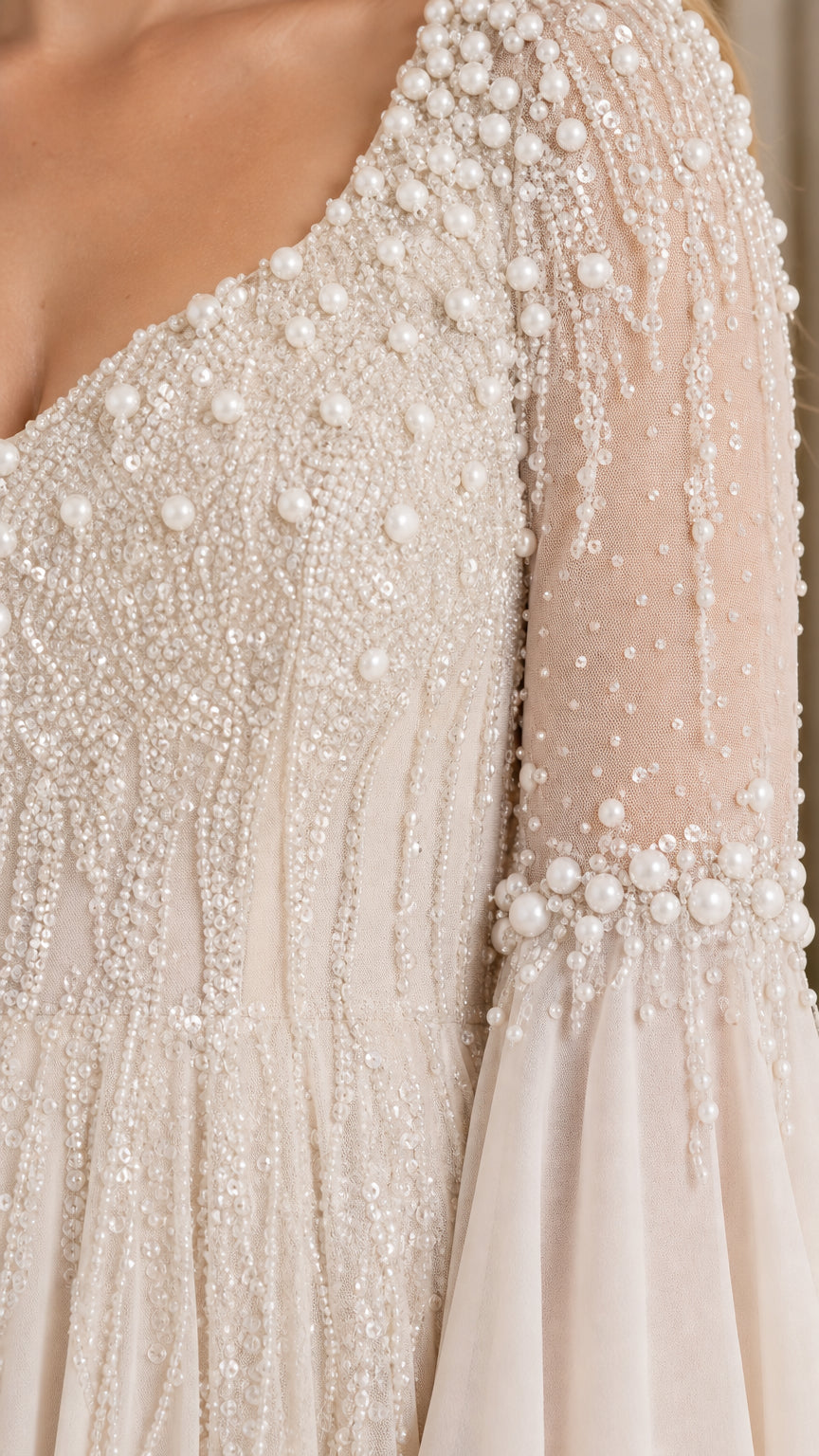 Detailed close-up of intricate pearl and bead embellishments on bodice and sleeve