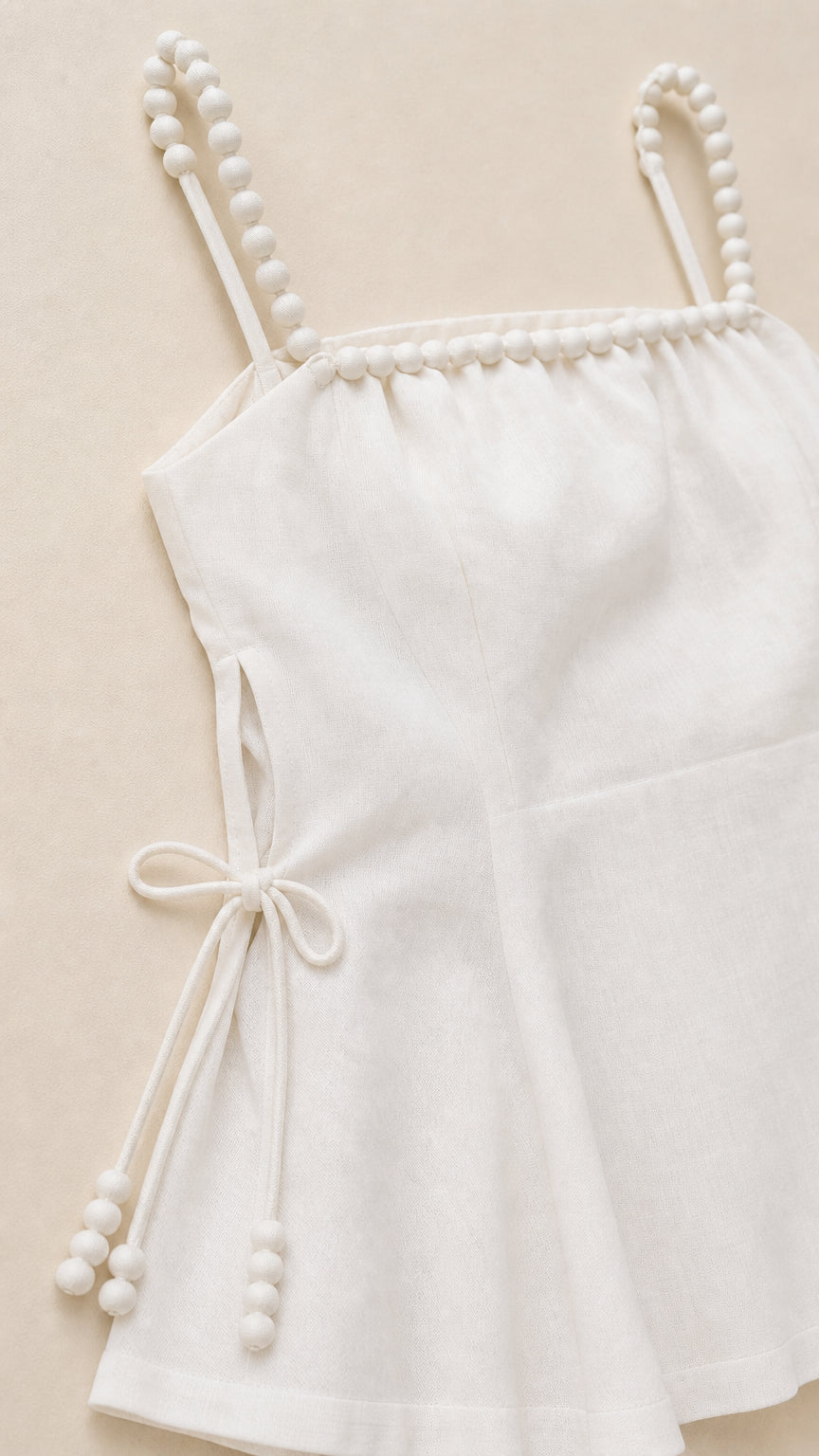 Close-up detail of white beaded straps and side tie