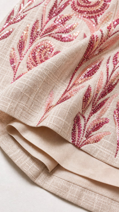 Close-up detail of textured fabric and sequin leaf embroidery