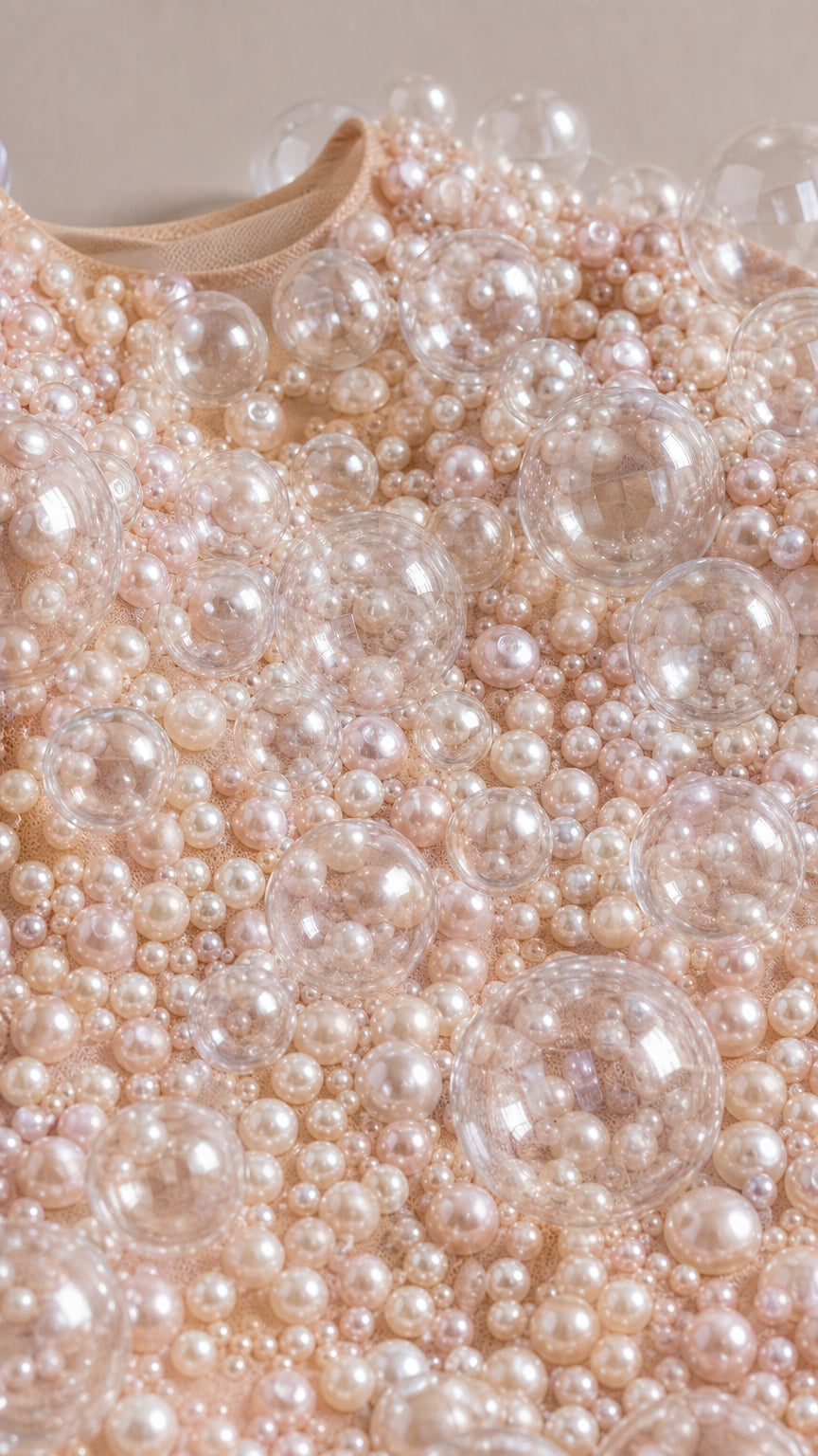 Close-up detail of translucent bubbles and faux pearls on dress fabric
