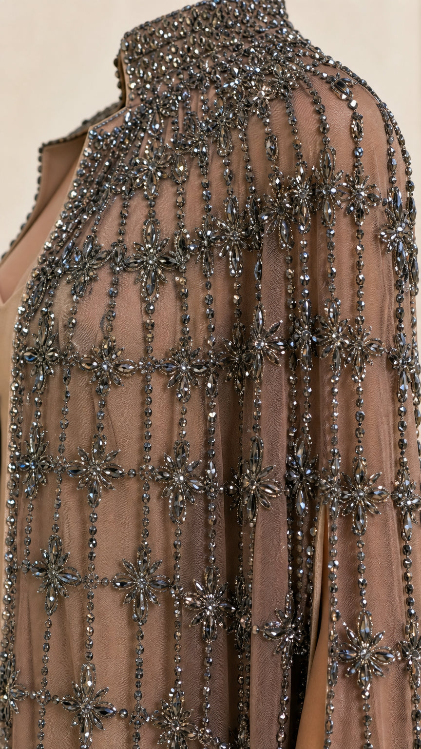 Close-up detail of high collar and intricate beadwork on taupe cape
