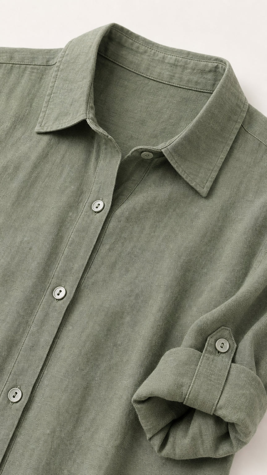Close-up of collar, button placket, and roll-tab sleeve on sage green dress