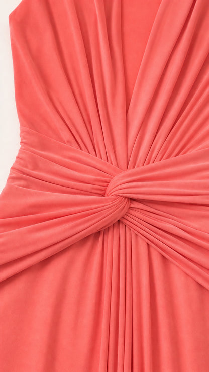 Close-up of gathered twist-knot and pleated fabric texture on coral dress