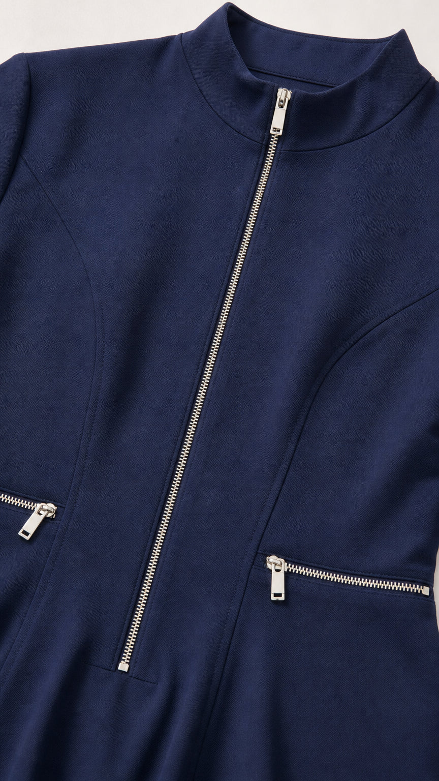 Close-up of mock neck and metallic zipper details on navy dress