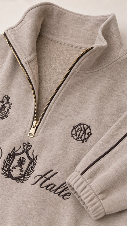 Close-up of the taupe quarter-zip collar, zipper, graphics, and cuff